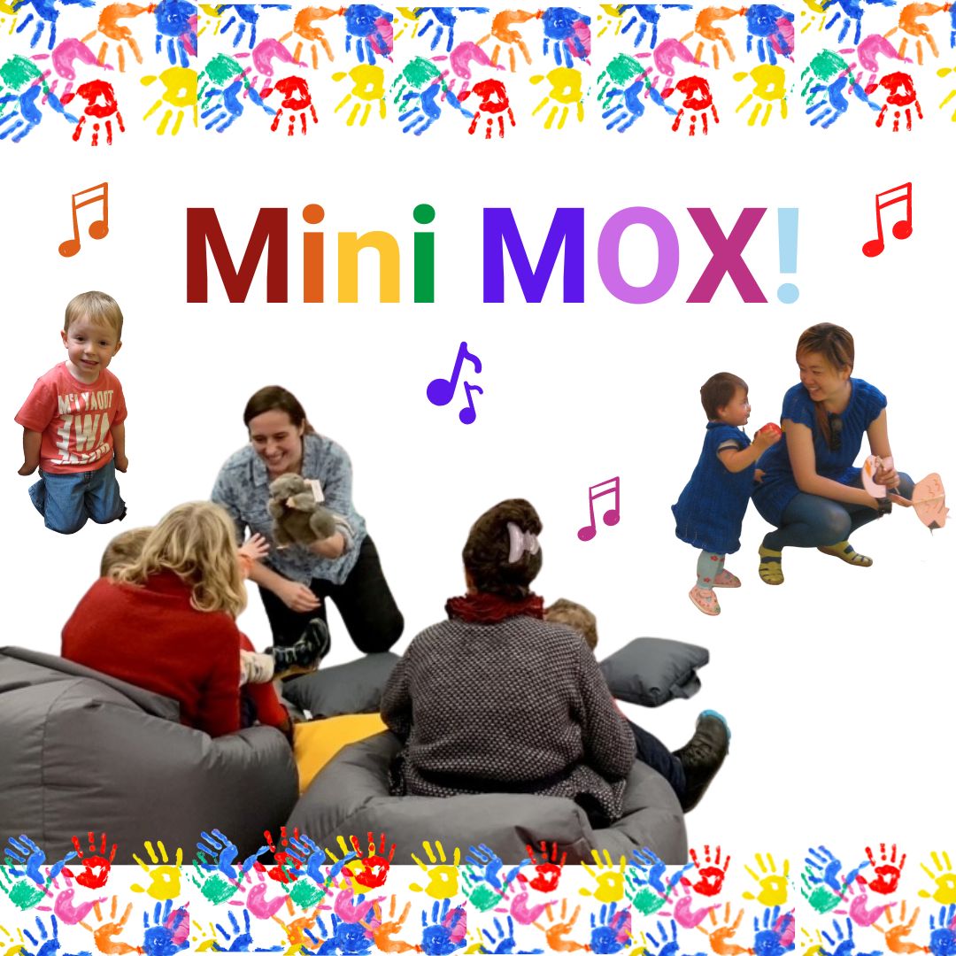 Adults and small children sit on beanags in front of a woman holding a rat glove puppet. In the background are a mother and toddler and a small boy. There is a border of handprints and the words Mini MOX in rainbow letters above.