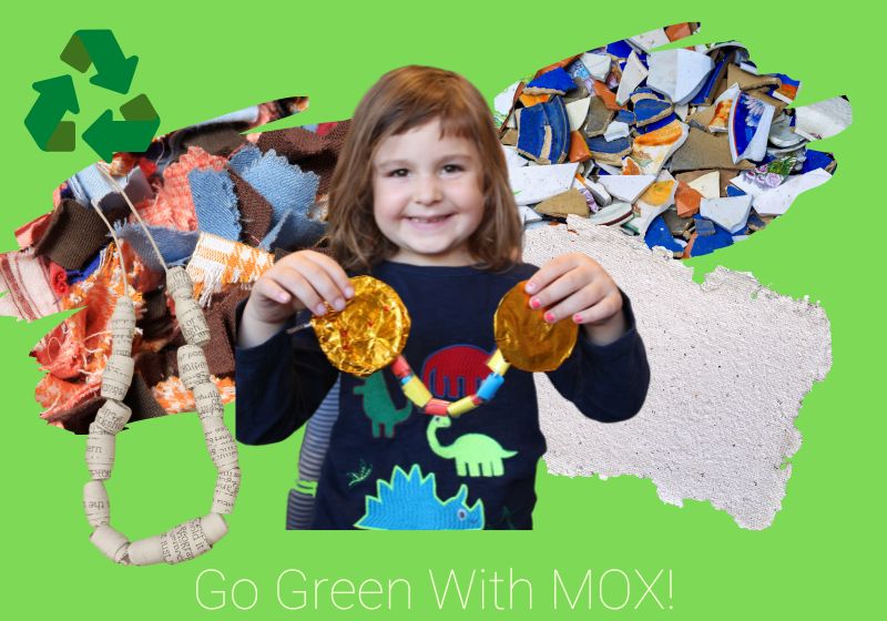 A small girl holding up a home made necklace stands in front of a rag rug, a piece of homemade paper and some broken crockery superimposed over a green background