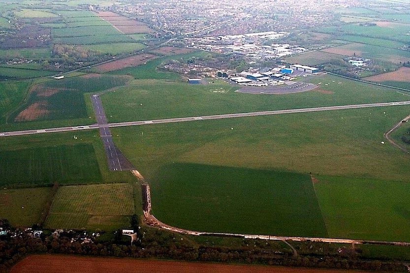 aerial photograph of London Oxford Airport buildings amongst green fields of Oxfordshire