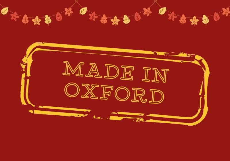 Red background with the text 'Made in Oxford' stamped onto it in yellow writing. Bunting made of autumn leaves at the top of the image.
