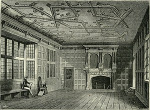 Black and white line drawing of a large room with an elaborate ceiling and wooden panel floor. A person can be seen sitting to the left of of the drawing on a chair next to the window. 
