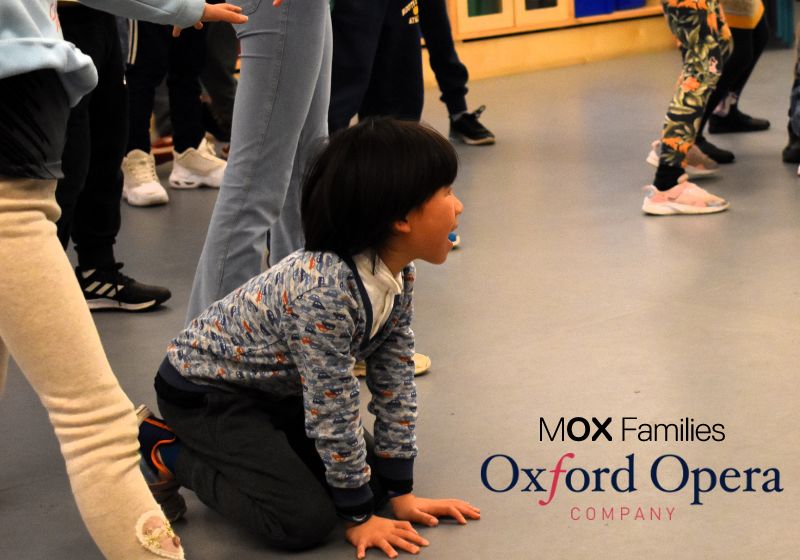 Young children are performing in the Museum Makers space. The image focuses on a young boy who is crawling in character of a fox.
