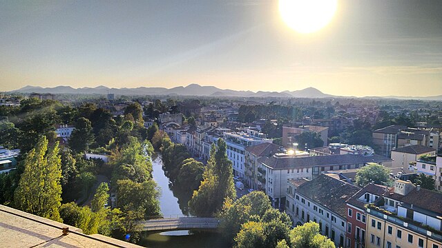 A photo looking over the city of Padua with buildings, trees and a river